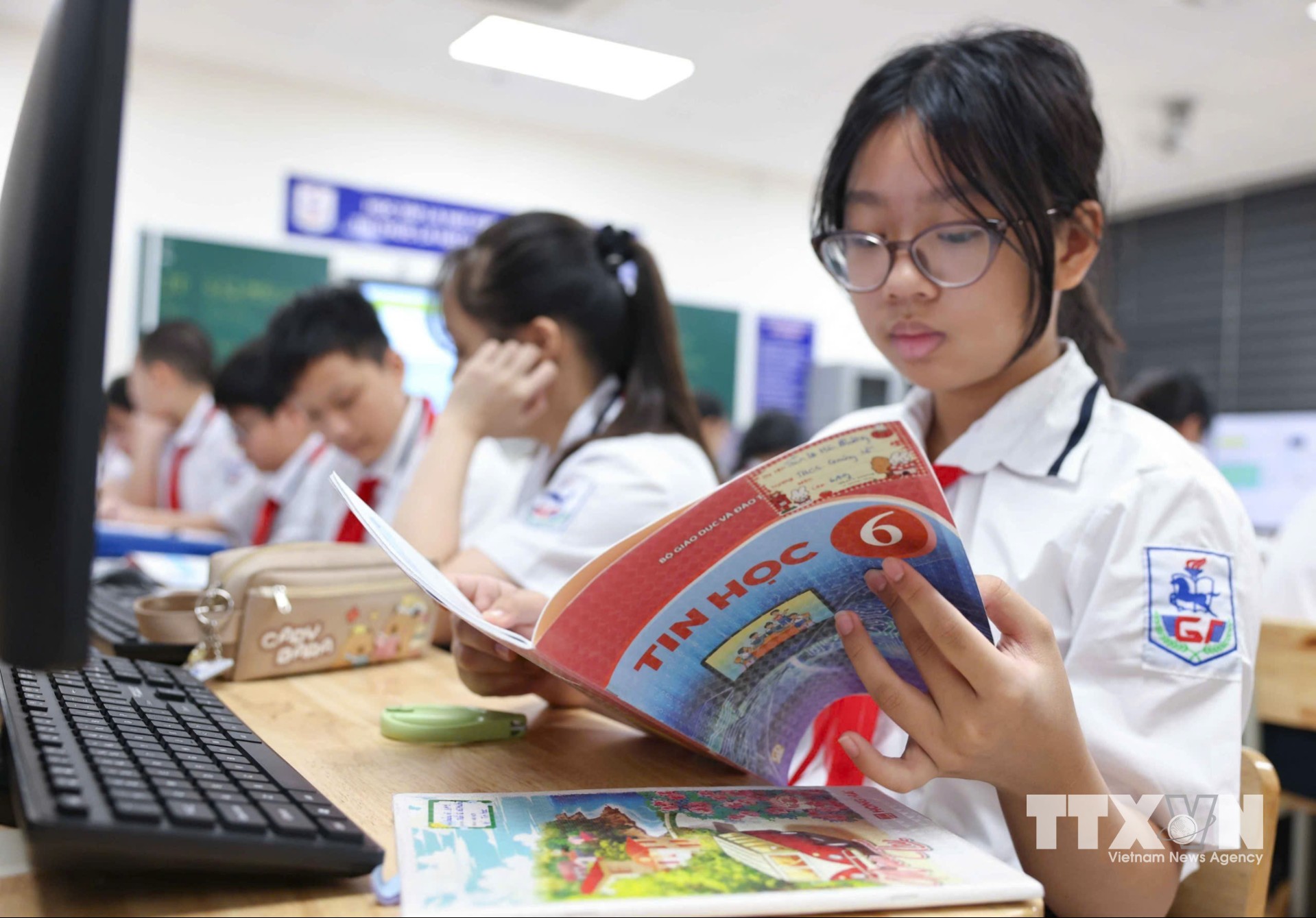 Học sinh được đọc hiểu kiến thức mới, trao đổi, chia sẻ trải nghiệm sử dụng Internet của bản thân và gia đình, từ đó nhận diện những hoạt động quen thuộc như tìm kiếm, chia sẻ, lưu trữ và trao đổi thông tin. (Ảnh: Thanh Tùng/TTXVN)